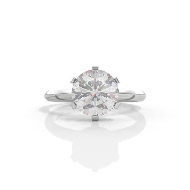 Pu&ograve; includere: Un anello d'argento con un grande diamante rotondo e trasparente incastonato in una montatura a sei griffe.