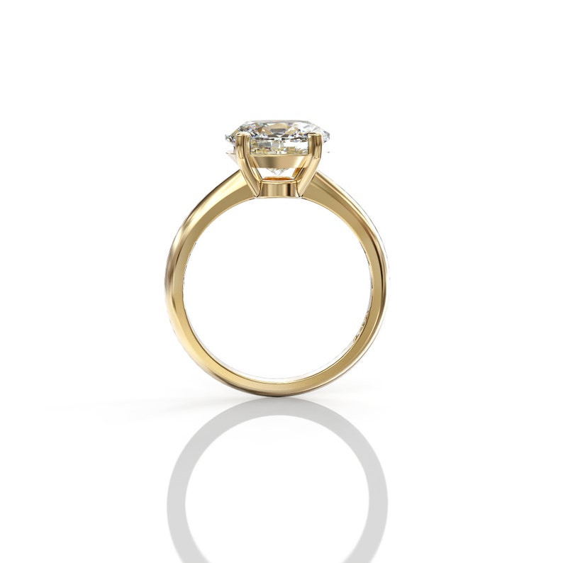 May include: A gold engagement ring with a large, clear, oval-shaped diamond.