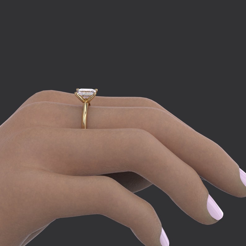 Pu&ograve; includere: Un anello di fidanzamento in oro con un grande diamante taglio smeraldo trasparente.