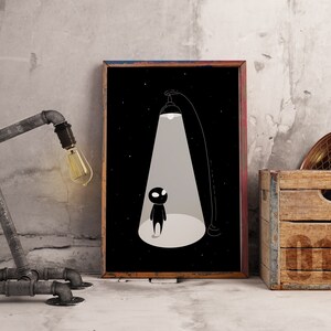 May include: A black and white illustration of a small figure standing in a beam of light. The figure is silhouetted against a dark background with stars. The illustration is framed and hanging on a wall.