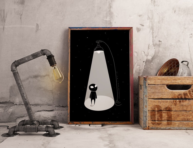 May include: A black and white illustration of a small figure standing in a beam of light. The figure is silhouetted against a dark background with stars. The illustration is framed and hanging on a wall.