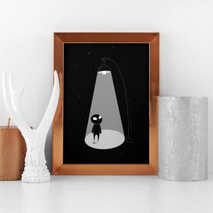 May include: A framed black and white illustration of a small figure standing in a spotlight against a starry night background.