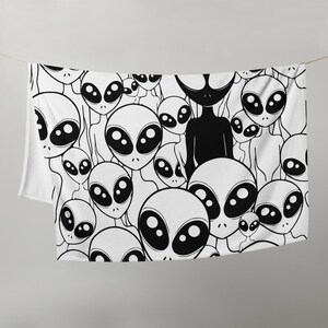 May include: Black and white illustration of a crowd of aliens with large eyes and one large alien in the centre. The aliens are all facing forward and have a simple design.
