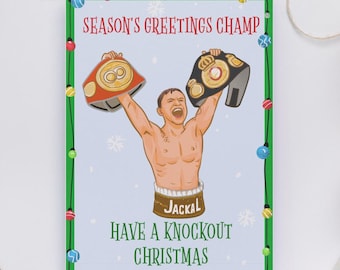 May include: A Christmas card with a cartoon illustration of a shirtless boxer holding up two championship belts. The card has the text "Season's Greetings Champ" and "Have a Knockout Christmas". The boxer's shorts say "Jackal". The card is framed with a green border.