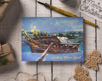 May include: A Christmas card featuring a boat with festive lights and a star on top, sailing on a snowy sea. The card has the text "Nollaig Shona Dhuit". The scene is set against a snowy landscape.