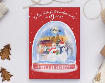 May include: A Christmas card with a red background and a snow globe illustration. Inside the globe are two snowmen, a building, and a flying sleigh. The card reads "To the Coolest Grandparents in Derry!" and "Happy Christmas."