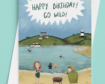 May include: A birthday card with a beach scene illustration. The card reads "Happy Birthday! Go Wild!" in a white burst. The scene includes people, a grill, a boat, and a lighthouse. The card is inside a white envelope.