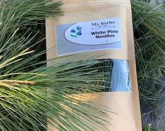 Może przedstawiać: Brązowa papierowa torba z białą etykietą, na której widnieje napis "My herbs for you" i "White Pine Needles". Torba leży na zielonych sosnowych igłach.