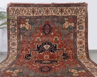 May include: A large, intricately patterned rug with a red, blue, and cream color scheme. The rug has a central medallion and a border with repeating floral motifs.