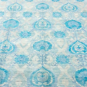 Puede incluir: Una alfombra azul claro con fondo blanco y un patr&oacute;n floral. La alfombra tiene un dise&ntilde;o tradicional con detalles intrincados.