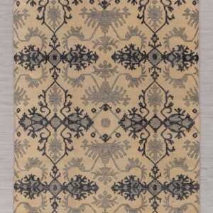 Puede incluir: Una alfombra beige con un patr&oacute;n geom&eacute;trico negro y gris. La alfombra tiene un borde de flecos y mide 6x9 pies o 180x270 cent&iacute;metros. C&oacute;digo de art&iacute;culo - 5274