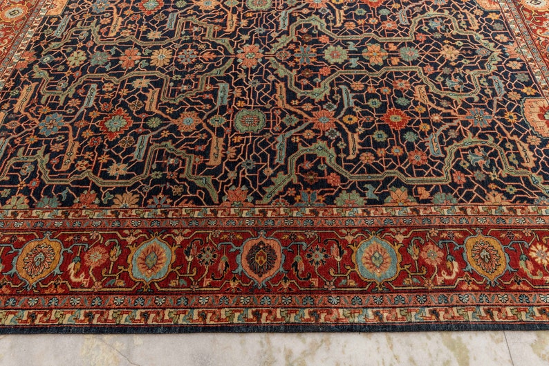 May include: A dark blue rug with a intricate floral pattern and a red border. The rug has a traditional Persian design.