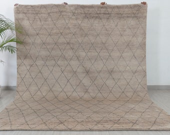 May include: A large, rectangular rug with a diamond pattern woven into the fabric. The rug is a light beige color with a darker beige diamond pattern.