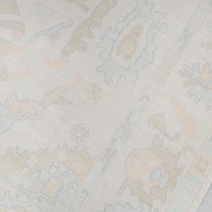 May include: A light beige rug with a subtle pattern of light blue and peach floral designs.