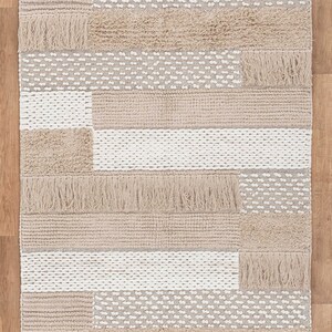 May include: A beige and white woven rug with a geometric pattern and fringe. The rug is 4x6 feet or 122x183 centimeters.