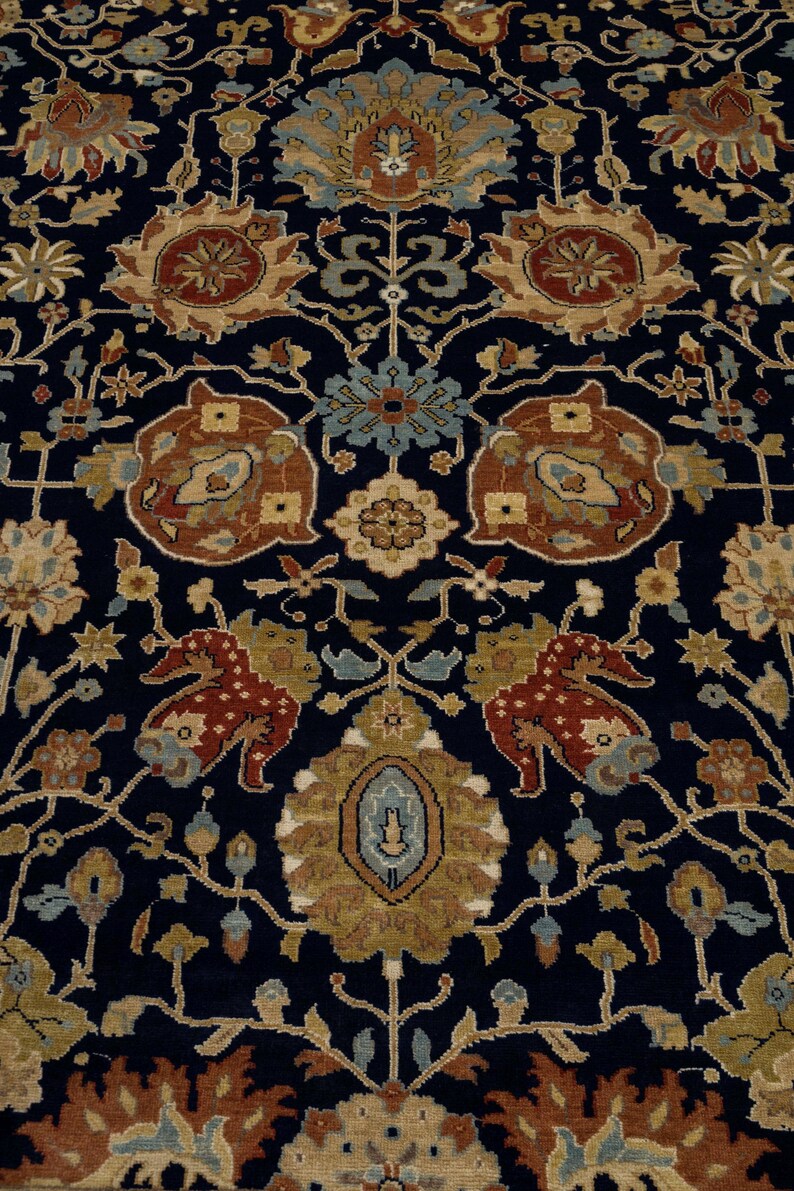 May include: A dark blue rug with a traditional Persian design featuring intricate floral patterns in shades of brown, beige, and blue.