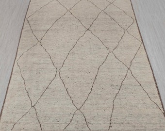 May include: A beige rug with a diamond pattern in brown. The rug has a subtle texture and a simple design.