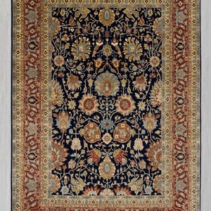 May include: A traditional Persian rug with a navy blue background and intricate floral patterns in shades of gold, red, and cream. The rug has a wide border with a repeating design. G-10682, Size - 9x12 ft, 274x366 cm.