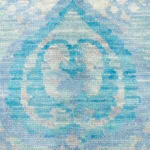 Puede incluir: Una alfombra azul y blanca con un dise&ntilde;o abstracto sutil. La alfombra tiene un tacto suave y texturizado y est&aacute; hecha de materiales de alta calidad.