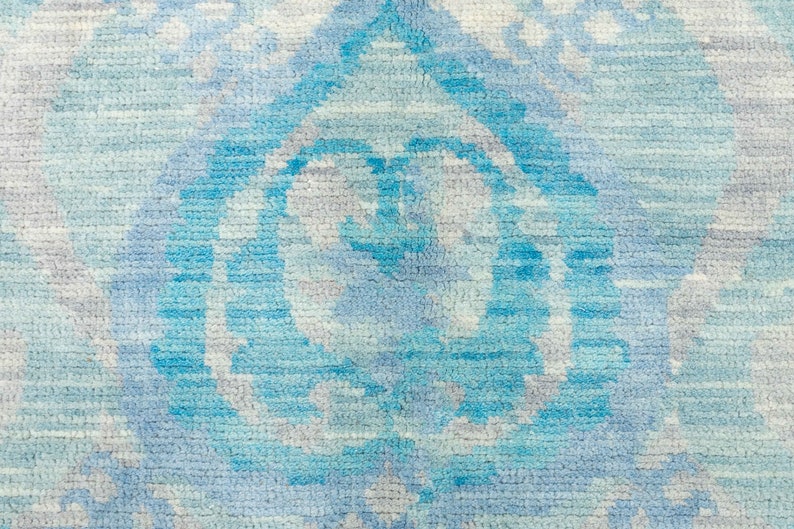 Puede incluir: Una alfombra azul y blanca con un dise&ntilde;o abstracto sutil. La alfombra tiene un tacto suave y texturizado y est&aacute; hecha de materiales de alta calidad.
