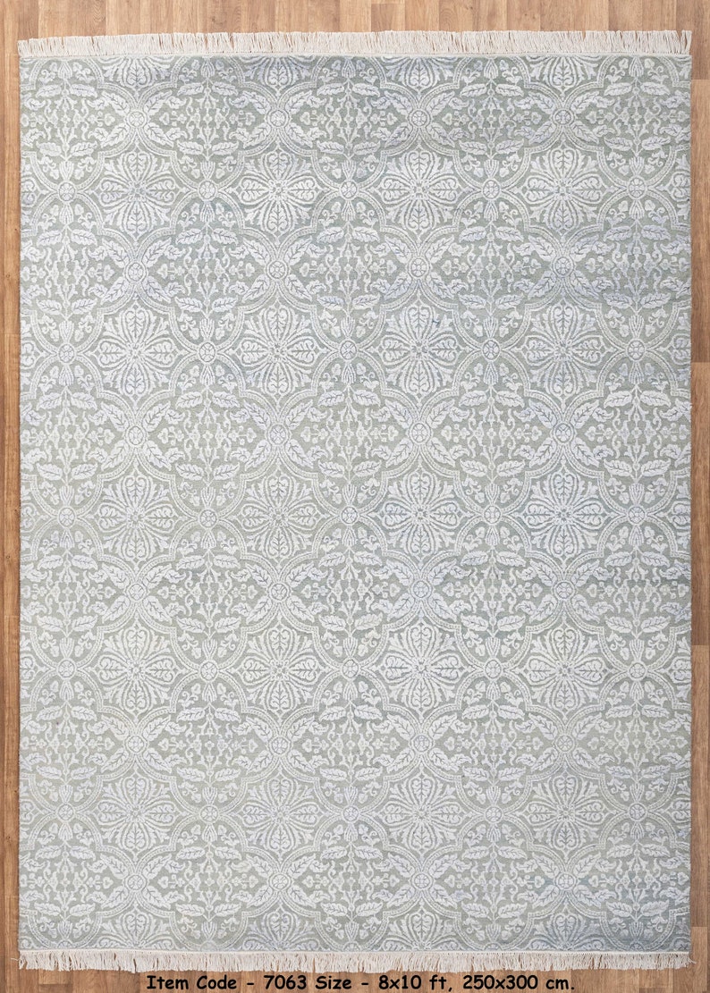 May include: A light gray area rug with a white floral pattern. The rug has a fringe border and measures 8x10 feet, or 250x300 centimeters. Item Code: 7063