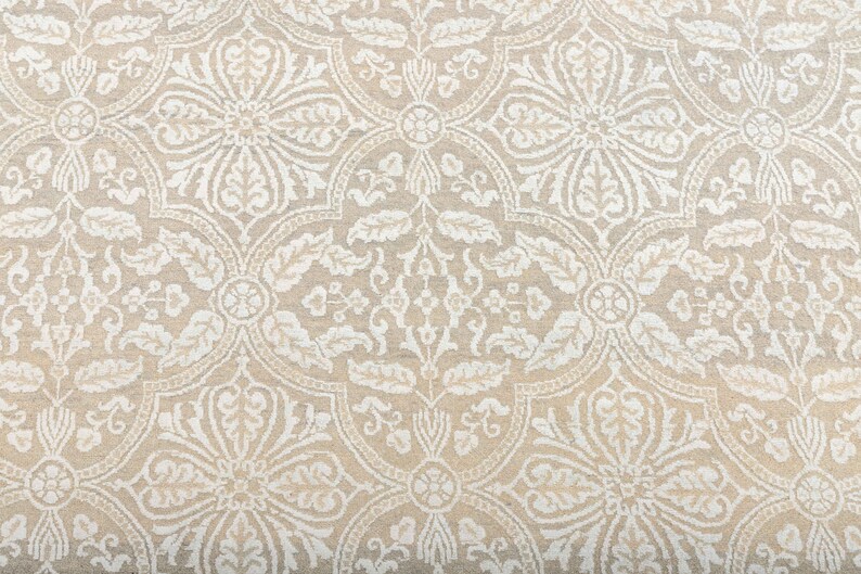 Puede incluir: Tela beige con un patr&oacute;n damasco blanco. El patr&oacute;n presenta intrincados dise&ntilde;os florales y motivos repetitivos.