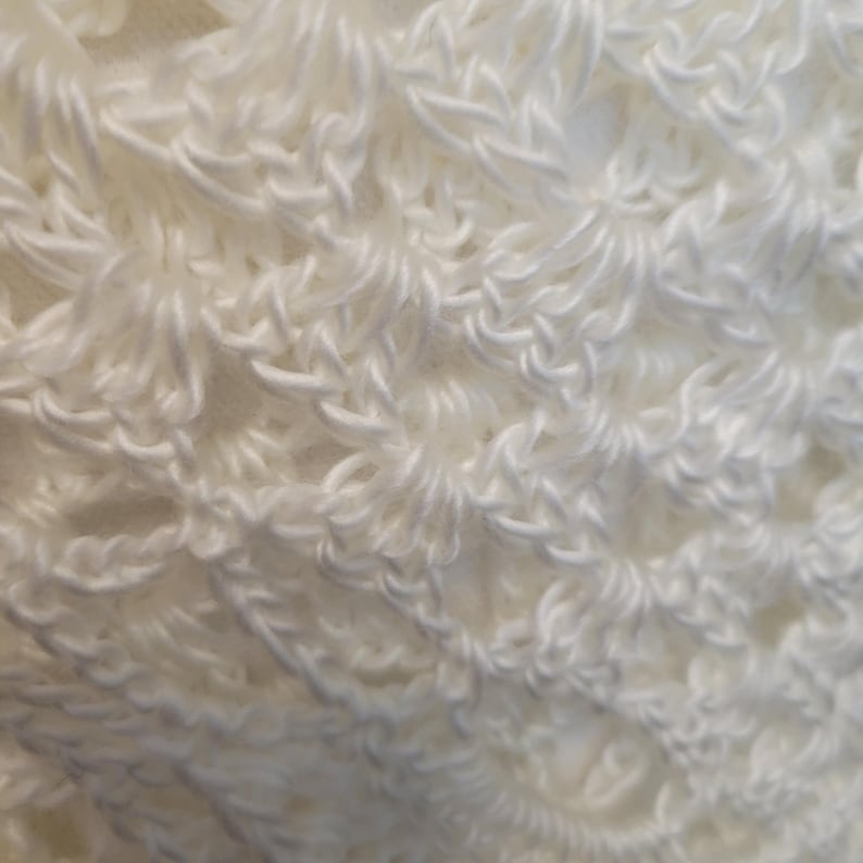 May include: White crocheted fabric with a textured, lacy pattern.