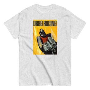 May include: A grey t-shirt with a vintage style illustration of a drag racing car with flames coming from the exhaust. The text "DRAG RACING" is printed in black at the top of the image.