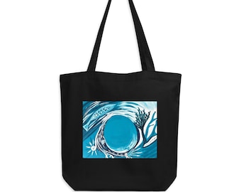 Puede incluir: Bolso tote negro con una pintura abstracta azul y blanca. La obra de arte representa un diseño circular con peces, corales y formas solares. El bolso tiene asas largas.