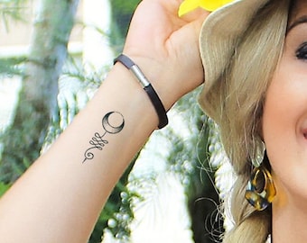 Può includere: Un tatuaggio temporaneo di una luna crescente con un design a vite sul polso di una persona.