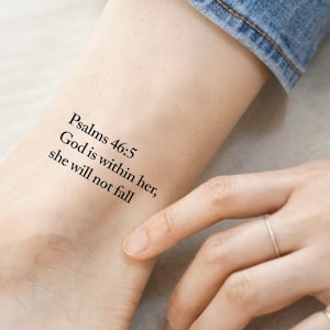 May include: A close-up of a person's ankle with a temporary tattoo that reads "Psalms 46:5 God is within her; she will not fall."