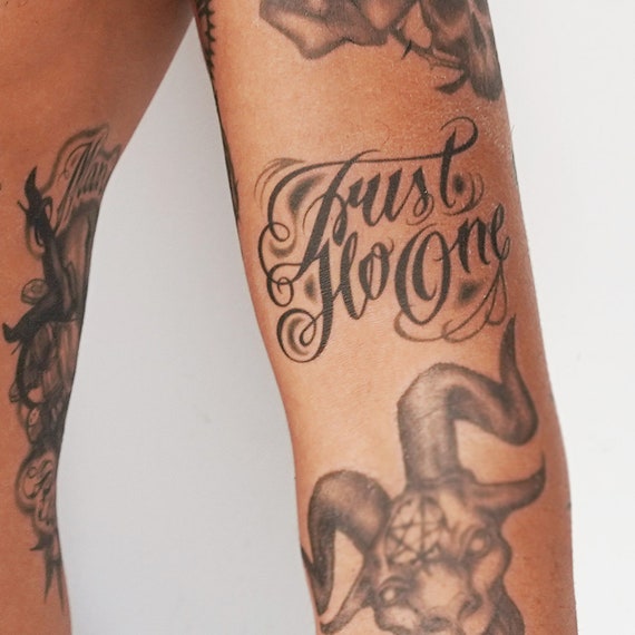 Trust no one tattoo on Saras forearm