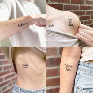 Op de afbeelding: Vier afbeeldingen met minimalistische tatoeages met inspirerende zinnen. De tatoeages bevatten de woorden "believe", "you got this", "actually I can" en "Dream Big" in elegant cursief schrift. De tatoeages zijn in zwarte inkt.