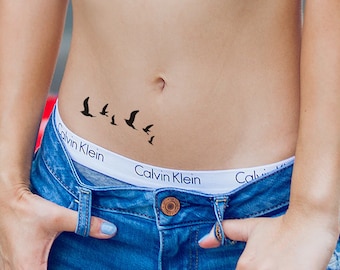 May include: A temporary tattoo of a flock of birds flying in a line, applied to a person's lower abdomen.