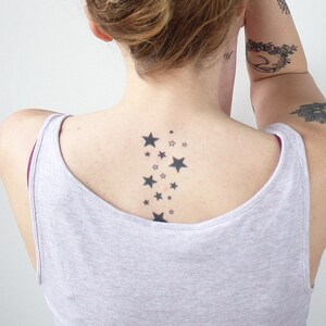 May include: A person with a tattoo of a constellation of stars on their back.