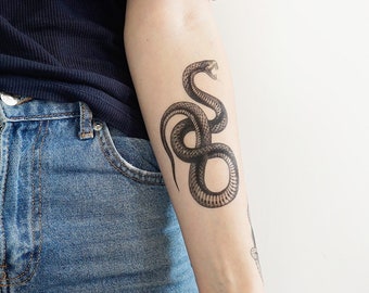 Puede incluir: Un tatuaje temporal de una serpiente en blanco y negro enroscada en posición defensiva.