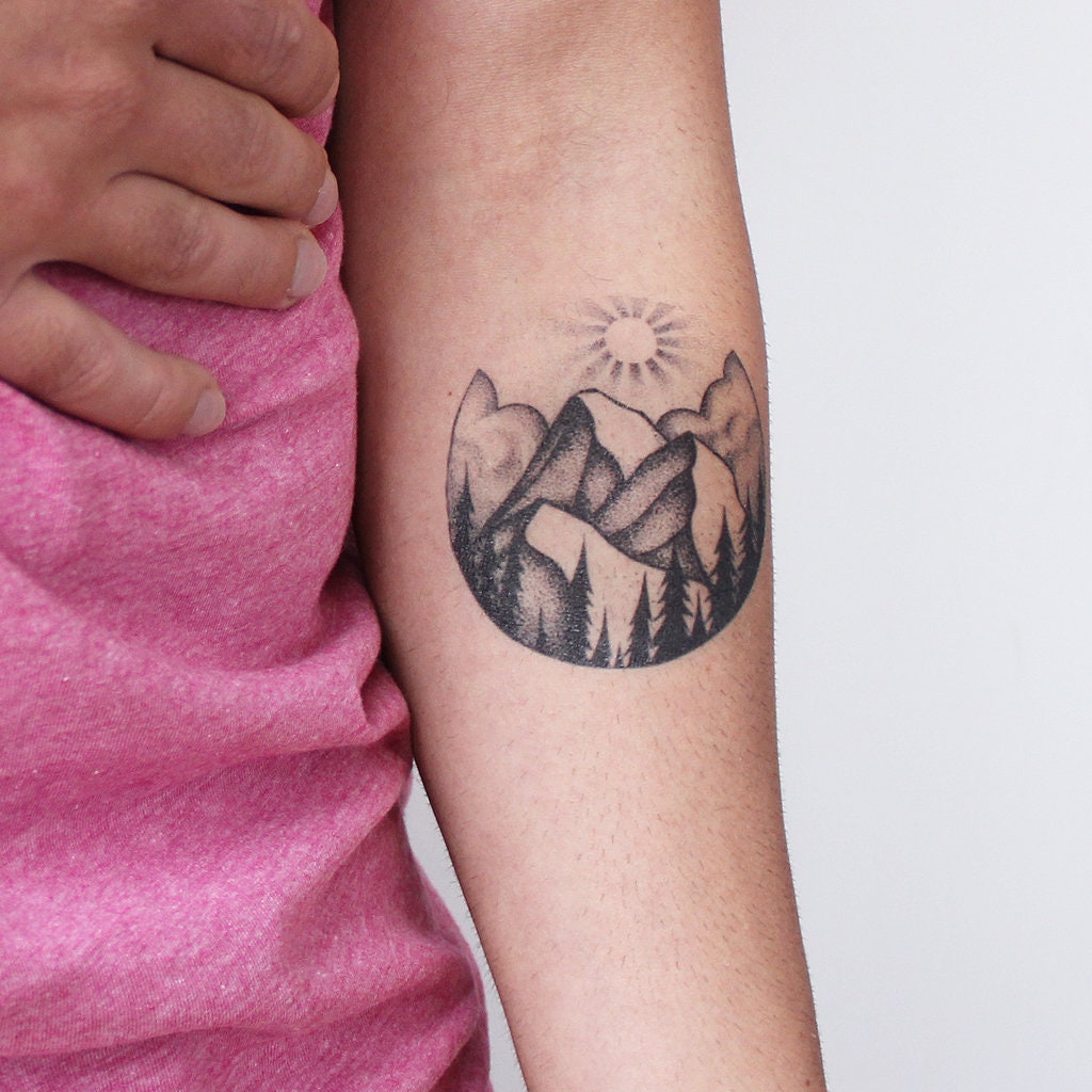 Minimalistic, black and white tattoo on male forearm. From the perspective  of being on the ocean,