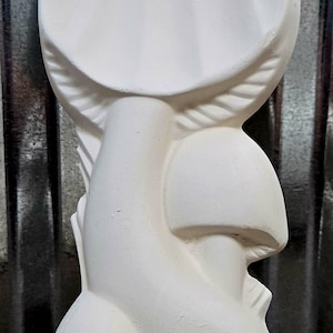 Puede incluir: Escultura de hongo de cerámica blanca con un gran sombrero redondeado y varias formas de hongo más pequeñas. La superficie texturizada sugiere un uso decorativo.