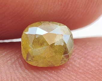 May include: A yellow, faceted, oval-shaped gemstone with a rough, natural finish.