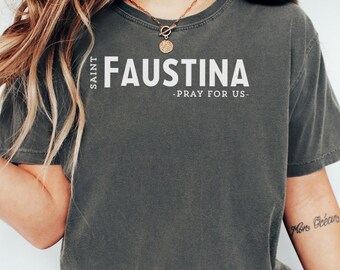 Könnte beinhalten: Ein graues T-Shirt mit dem Aufdruck "SAINT FAUSTINA - BETE FÜR UNS -" in weiß.