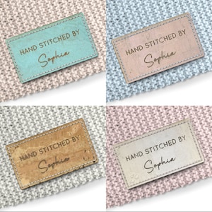 May include: Four hand-stitched fabric labels with the text "HAND STITCHED BY Sophia" in a handwritten font. The labels are in different colors and textures, including blue, pink, brown, and white.
