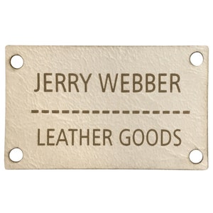 Puede incluir: Una etiqueta de cuero blanco con texto marrón que dice "JERRY WEBBER" y "LEATHER GOODS" con una línea discontinua entre las dos líneas de texto. La etiqueta tiene cuatro agujeros en las esquinas.
