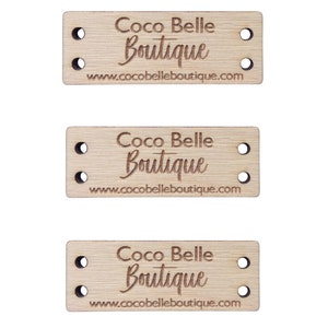 Può includere: Tre etichette rettangolari in legno con il testo "Coco Belle Boutique" e l'indirizzo del sito web www.cocobelleboutique.com. Ogni etichetta ha due fori su ciascuna estremità per il fissaggio agli articoli.
