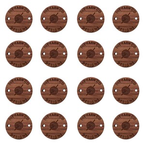 May include: Twelve round wooden tags with the text "The Yarn Co. Designs" and a graphic of a ball of yarn with a needle.