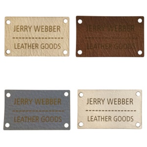 Peut inclure: Quatre étiquettes en cuir avec le texte "JERRY WEBBER" et "LEATHER GOODS" en lettres dorées. Les étiquettes sont de quatre couleurs différentes : beige, marron, gris et blanc.