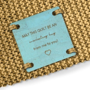 May include: A blue wooden tag with the text "May this quilt be an everlasting hug from me to you!" and a heart symbol.