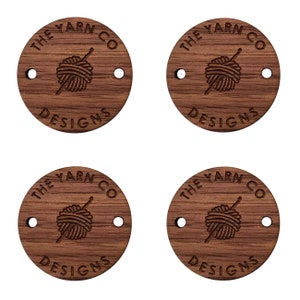 May include: Four round wooden tags with the text "THE YARN CO DESIGNS" and a stylized image of a ball of yarn with a needle.