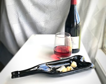Opgesmolten gefietste wijnfles. Gesmolten glazen wijnflessen.  Flessenschaal van gesmolten glas. Wijnfles kaas- en snackplateau. Gerecycleerde glazen fles