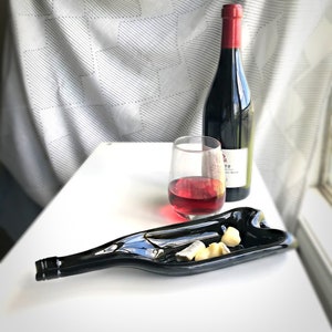 溶けたリサイクルワインボトル。溶けたガラスワインボトル。溶けたガラスボトルの皿。ワインボトルのチーズとスナックのトレイ。リサイクルガラスボトル