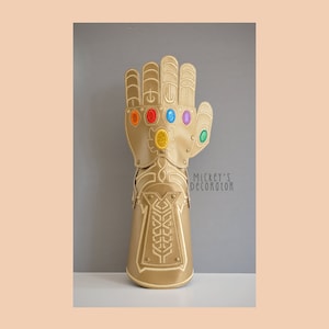 Pode incluir: Uma luva dourada com um design detalhado e seis gemas coloridas. A luva é uma réplica da Manopla do Infinito do Universo Cinematográfico Marvel.